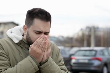 Sticker - Sick man coughing outdoors, space for text. Cold symptoms