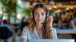 © evgeniia_1010 - A young pretty woman with headphones and a microphone on the background of a modern office. A support worker advises clients in a call center.