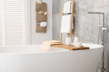 Wall Mural - Set of different bath accessories and soap on tub in bathroom, space for text