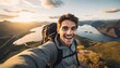 Young man traveler with backpack taking selfie on top of the mountain.
