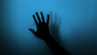 © Vladimir - Hand silhouette on blue background. Blurred human hand shape out of focus