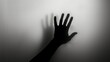 © Vladimir - Hand silhouette on grey background. Blurred human hand shape out of focus