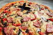 Homemade round pizza with sausage, peppers, tomatoes and basil. High quality photo