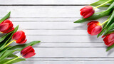 Fototapeta Tulipany - Tulipany, czerwone wiosenne kwiaty na białej desce, puste miejsce