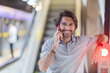 © Buonaventura - View of young man using a smartphone inside a subway - metro station with a blurred view landscape in the background. High quality video. Texting, talking on the phone.