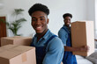 © wolfhound911 - Portrait of a two African American young male happy smiling employee of moving service in overall standing in the living room of new house holding cardboard boxes in hands