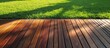 Deck boards made of Ipe hardwood with evergreen grass alongside the exotic wood floor planks.