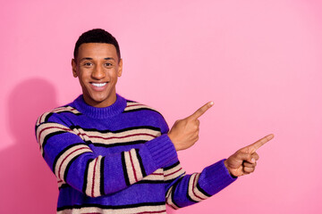 Photo of positive sweet man wear striped sweater showing two fingers empty space isolated pink color background