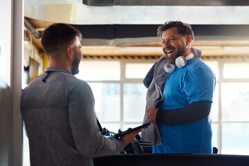 Wall Mural - Happy mature man having exercise class with personal trainer in  gym.