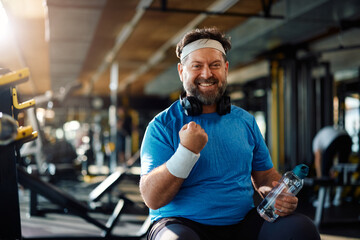 Wall Mural - Happy mature athlete feeling satisfied after successful sports training in gym and looking at camera.