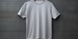 Silver t shirt is seen against a gray wall