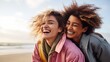 © Oleg Kozlovskiy - An exuberant moment captures two friends bursting into laughter, with the wind in their hair and the beach as their backdrop, showcasing a carefree and joyful companionship