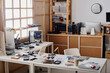 © AnnaStills - Empty workshop interior with big amount of tools and elements of faulty electronic devices displayed on table