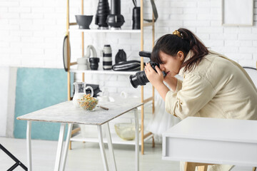 Wall Mural - Female food photographer taking picture of cereal rings with milk in studio