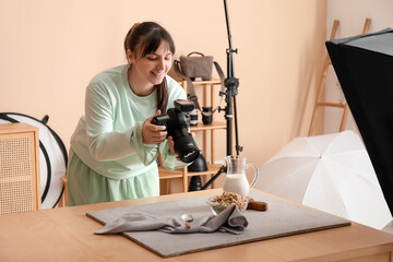 Wall Mural - Female food photographer taking picture of tasty cereal rings with milk in studio