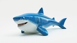 Fototapeta Las - A blue and white toy shark with its mouth open. Funny cute inflatable toy on white background.