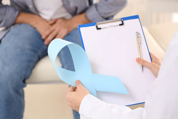 Sticker - Urologist with blue ribbon and clipboard at hospital, closeup. Prostate cancer awareness concept