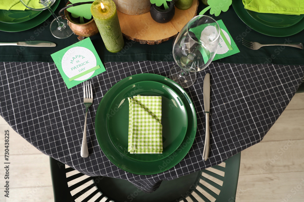 Festive table serving with folded napkin and greeting card for St. Patrick's Day celebration, top view