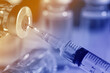 © New Africa - Filling syringe with medicine from vial against blurred background, closeup. Color toned