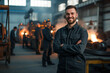 © Alina Zavhorodnii - A man in work clothes smiling in the background of production in a factory with sparks and fire, Steelworkers welders foundry workers