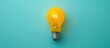 A yellow light bulb copy space isolated on light blue background. AI generated image