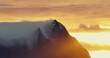 Majestic Mountain Peaks Piercing Through Mist at Sunset