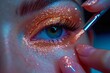 Applying glitter makeup on vibrant, colorful eyeshadow