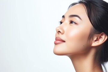asian woman with flawless skin in a side view on a white background undergoing facial treatment for 