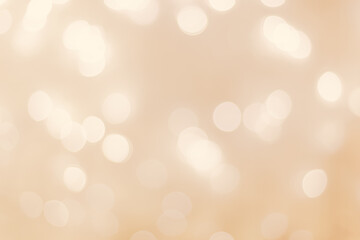 Defocused abstract bokeh background beige pastel colored, flare from lights, beige monochrome photo, blurred round bokeh as holiday fon, celebration wallpaper. Glittering aesthetic pattern