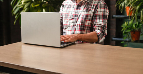 Young man typing on laptop. Banner of a student studying on a computer. Stylish design freelancer at work