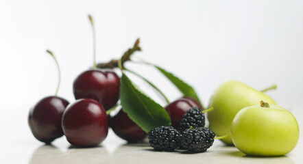 Wall Mural - Red cherries and fruits on white mar