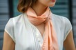 businesswoman with a peach scarf neatly tucked into a white blouse