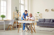 © Studio Romantic - Senior man doing puzzles while sitting at desk in cozy retirement home interior. Friendly nurse helping demented old man while playing games and doing puzzles. Senior care, Alzheimer disease concept