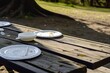 park picnic table with paper plates and plastic cutlery