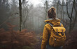 A women with a backpack walking in the middle of thee forest