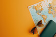 Travel Planning Concept with World Map, Sunglasses, and Passport on a Vibrant Orange Background