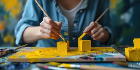 Poster - A woman is painting with yellow paint on a canvas. This image can be used for artistic or creative projects