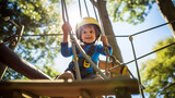 Fototapeta Konie - A young child wearing a safety harness climbing a rope ladder in an adventure park