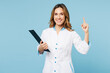 © ViDi Studio - Female doctor woman wearing white gown suit work in hospital clinic office hold clipboard with medical documents point index finger up isolated on plain blue background. Health care medicine concept.