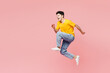 Full body side view cool fun overjoyed young man he wears yellow t-shirt casual clothes jump high run fast hurry up isolated on plain pastel light pink background studio portrait. Lifestyle concept.