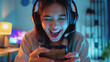 Young woman wearing headset and playing online game on smartphone