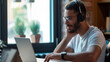 © MYDAYcontent - A black handsome man seated using a laptop and wearing headphones, student or entrepreneur work with data