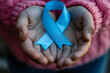 Child Holding Blue Ribbon for Juvenile Arthritis Awareness