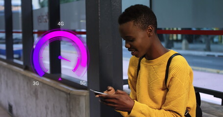 Wall Mural - Image of purple speedometer over happy african american boy using smartphone