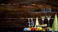 Solemn Background For The Anniversary With The Number  13. Happy Birthday Background On Brown Wooden Background With Champagne Bottle And Champagne Glasses. Beautiful Holiday Decorations Copy Space.