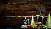 Solemn Background For The Anniversary With The Number  21. Happy Birthday Background On Brown Wooden Background With Champagne Bottle And Champagne Glasses. Beautiful Holiday Decorations Copy Space.
