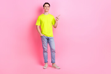 Poster - Full length photo of cheerful good mood man dressed yellow t-shirt showing finger empty space isolated pink color background