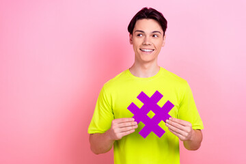 Sticker - Photo portrait of nice teen man hold hashtag look empty space wear trendy yellow clothes isolated on pink color background