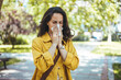 © Dragana Gordic - Woman struggling with allergy. Itchy eyes and sneezing. Attractive young adult woman coughing and sneezing outdoors. Sick people allergy or virus influenca concept.