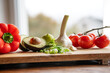 Healthy vegetables and fresh ingredients on wooden cutting board in front of bright kitchen window. Healthy nutrion concept for a spring diet. Space for text.